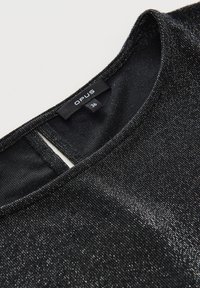 Schwarzes Kurzarmoberteil mit metallischem Glanz, ausgestattet mit einem Rundhalsausschnitt und einem Schlüsselhole-Detail am Rücken. Das Etikett zeigt die Marke "OPUS" und die Größe "36."