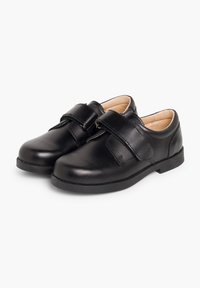 Chaussures en cuir noir avec un bout arrondi, fermeture à bande velcro et semelle en caoutchouc plate. L'intérieur est doté d'une doublure de couleur claire.