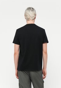 Sort bomulds T-shirt med korte ærmer og rund hals. Enkel design, glat tekstur, ingen synlige mønstre eller detaljer.