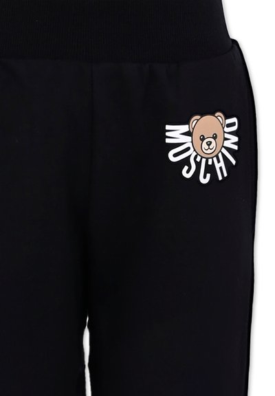 Zwarte trainingsbroek met een zachte textuur, voorzien van een berenafbeelding en de tekst "Moschino" in het wit, geplaatst op het bovenbeen.