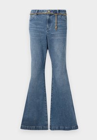 Jean évasé en denim bleu avec poches avant et ceinture chaîne dorée suspendue lâchement autour de la taille.