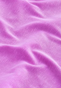 Soft, light purple fabric with fine weave texture, displaying gentle folds and subtle shading across the surface.