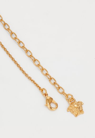 Gold-tone chain necklace with alternating link shapes, featuring a lobster clasp and a pendant of a lion head. Smooth texture, shiny finish.