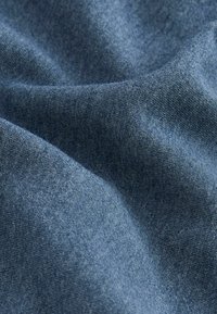 Material textil de un albastru închis, cu o textură moale, prezentând variații subtile de nuanță și un model de țesătură fină. Materialul se așează uniform.
