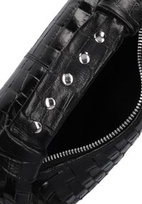 Schwarze geflochtene Lederhandtasche mit glänzenden silbernen Knöpfen am Riemen und einem metallischen Reißverschluss, ausgestattet mit einem glatten Innenfutter.