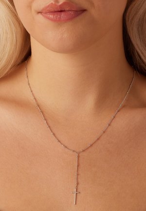 Collier en argent avec une chaîne à perles et un pendentif en croix verticale, présentant une texture lisse et un design minimaliste.