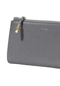 Clutch in pelle grigia con finitura testurizzata, zip in metallo dorato e dettaglio logo impresso. Forma rettangolare compatta.
