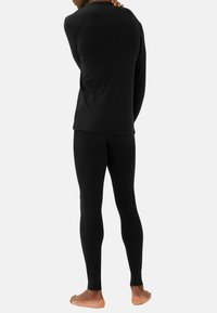 Svart termisk långärmad topp och leggings i ribbat tyg, med en åtsittande design och mjuk textur.