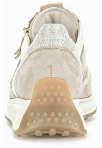 Beżowe zamszowe sneakersy z białymi akcentami i metalicznym, teksturowanym wykończeniem. Posiadają gumową podeszwę z okrągłymi wzorami antypoślizgowymi oraz zamek błyskawiczny z tyłu.
