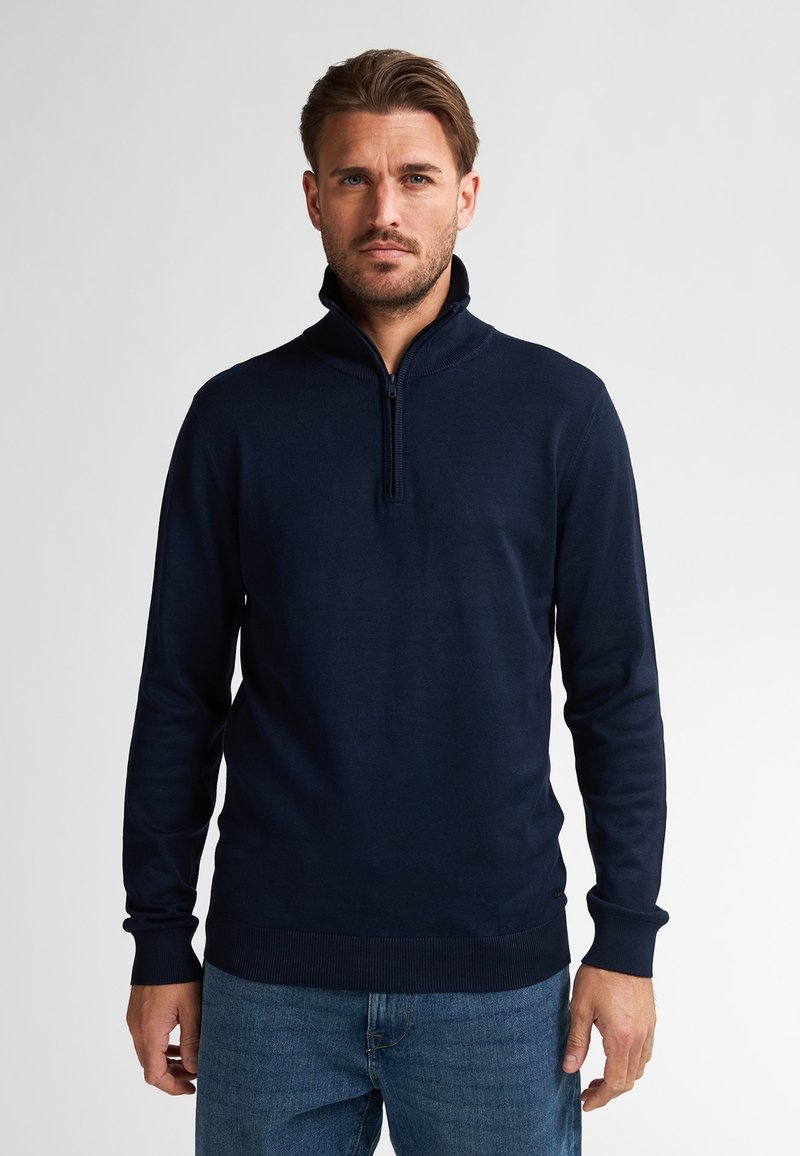 Donkerblauwe sweater met rits en lange mouwen, geribde manchetten en zoom, gemaakt van een zachte, rekbare breisels. Eenvoudig ontwerp, geen patronen.