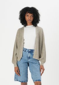 Beige gebreide cardigan met een losse pasvorm, geribde textuur, open voorkant en lange mouwen, gecombineerd met lichtblauwe denim shorts met hoge taille.