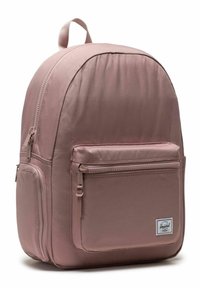 Sac à dos en tissu rose avec un haut arrondi, poche frontale zippée et une poche latérale. Comprend une poignée en boucle et des bretelles ajustables.