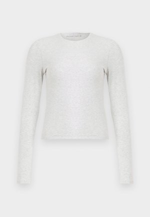 Tricou gri cu mânecă lungă, realizat dintr-un material moale și elastic. Are un decolteu rotund și o formă ajustată. Textură netedă, fără modele.