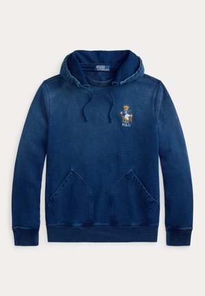 Tmavomodrá mikina s kapucňou a klokankovým vreckom, s nastaviteľnou kapucňou a vyšitou postavičkou medveďa Polo v bundičke sediaceho na stoličke na hrudi.