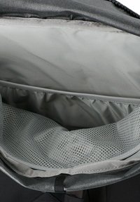 Offener grauer Rucksack, der ein leeres Innenfach mit einem Netzfach und einem gefütterten Bereich zur Organisation zeigt.