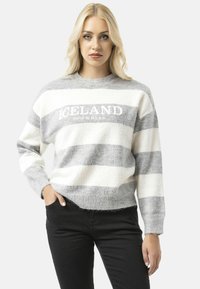 Pull rayé gris et blanc à col rond, affichant le mot "ISLANDE" en broderie blanche sur la poitrine. Texture douce.