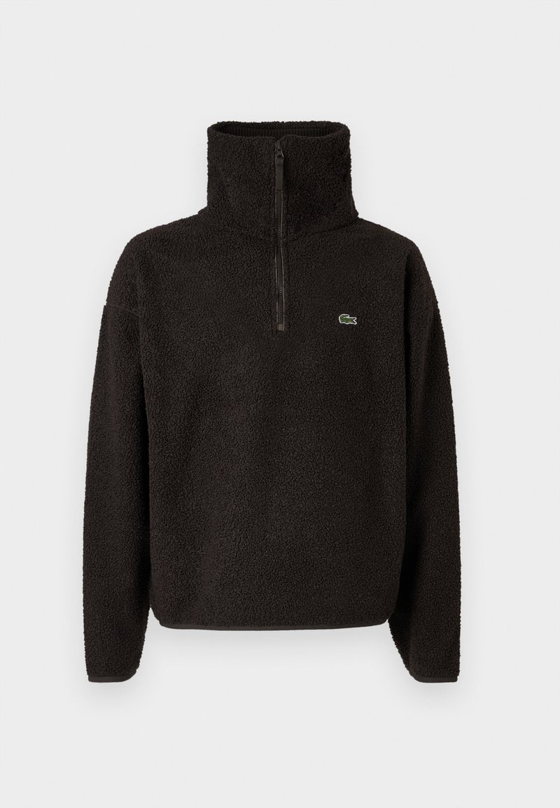 Sort fleece-pullover med høj krave og halvlængde lynlås, med lange ærmer og et lille grønt logo på brystet. Blød tekstur.