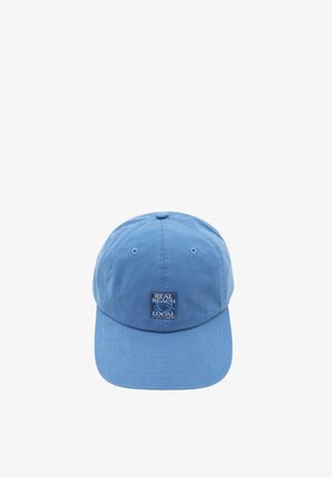 Șapcă de baseball bleu deschis cu o mică etichetă pătrată pe care scrie "REAL BEACH LOCAL" și cu un grafic cu crab în centrul frontal.