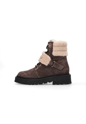 Stivale alla caviglia in suede marrone con colletto in pelo sintetico crema, dettagli in pizzo e cinture, suola in gomma nera spessa e design della punta arrotondata.