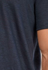 Navyblå kortärmad t-shirt i texturerad tyg; har en avslappnad passform med lätt lyster och subtila färgvariationer.