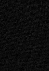 Tissu noir avec une surface texturée, présentant un motif de tissage fin. Le tissu est opaque et uniforme en couleur sur toute sa surface.