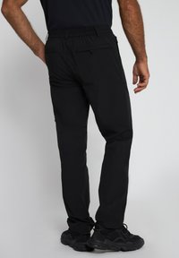 Zwarte sportbroek met een elastische tailleband, zijzakken en een gladde textuur. Het ontwerp is functioneel en aansluitend voor een gemakkelijke beweging.