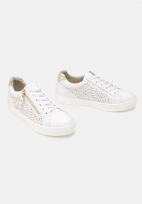 Fehér perforált bőrsneaker arany díszítéssel a sarkán, fűzős záródással és oldalsó cipzárral. Lapos, strukturált gumitalp.