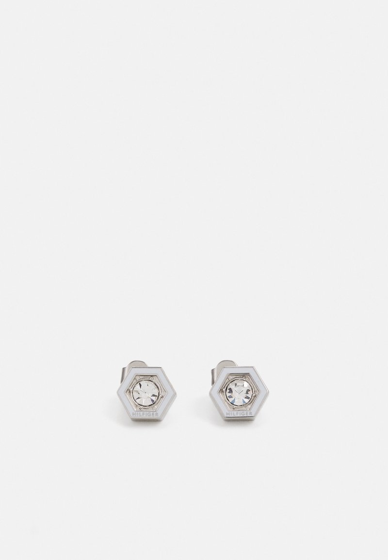 Pendientes de tuerca hexagonales en plata con un cristal claro central. Presentan una superficie pulida y una marca grabada en el lateral.