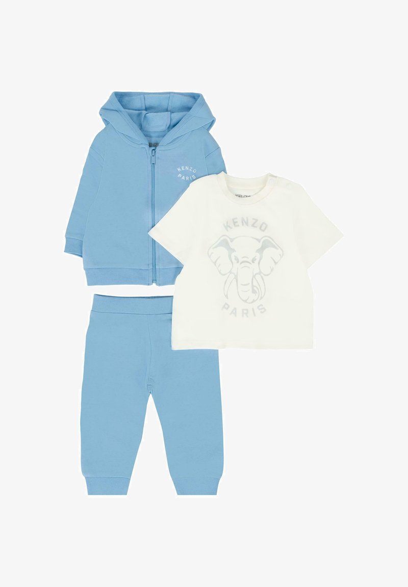 Felpa con cappuccio azzurro chiaro con cerniera, pantaloni coordinati e t-shirt bianca con grafica di un elefante, tutti realizzati in morbido cotone.