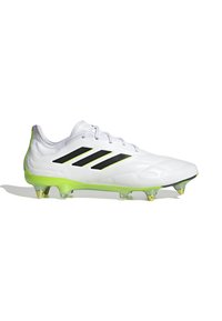 Scarpa da calcio bianca con strisce nere, dotata di suola traslucida verde e tacchetti a punta, realizzata in materiale sintetico.