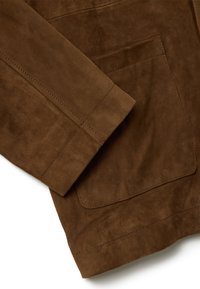 Manica di giacca in camoscio marrone con una superficie liscia. Presenta una tasca e cuciture visibili lungo l'orlo e le cuciture per un tocco di dettaglio in più.