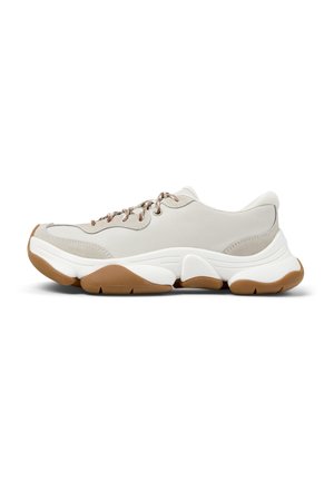 Sneaker grigio chiaro con pelle testurizzata e inserimenti in mesh. Presenta lacci marroni e una suola spessa bianca con accenti in gomma. Forma arrotondata.