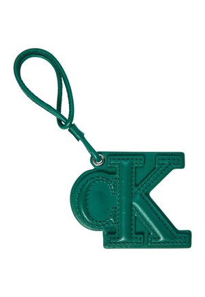 Breloc din piele verde în formă de litere „d” mici suprapuse și „K” mari, cu o bandă buclată atașată.
