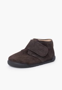 Gheată de gleznă maro închis din piele întoarsă, cu o curea cu velcro, vârf rotund, partea superioară texturată și talpă flexibilă din cauciuc pentru confort și ușurință în purtare.