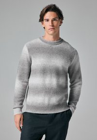 Grauer Strickpullover mit rundem Ausschnitt und Rippbündchen. Verf�ügt über ein Farbverlaufsmuster mit hellen zu dunklen Farbtönen.