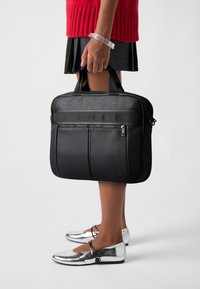 Sac à ordinateur portable en cuir noir avec deux poches zippées à l'avant, des poignées de transport et une texture lisse. Design plat, adapté à un usage professionnel.