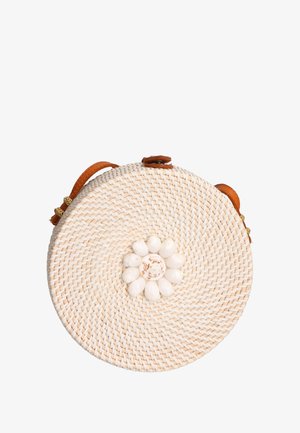 Ronde geweven stro tas met een lichtbruine leren schouderriem, met in het midden een witte schelp bloemdecoratie en een gestructureerd oppervlak.