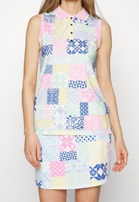 Ärmlös klänning med en rosa krage, med ett lapptäcke-design i pastellfärger som inkluderar blå, gula och rosa geometriska mönster.