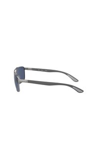 Occhiali da sole rettangolari con lenti blu scuro, montatura in metallo grigio e bracci in gomma grigia. Dettagli notevoli includono accenti argentati sulle cerniere.