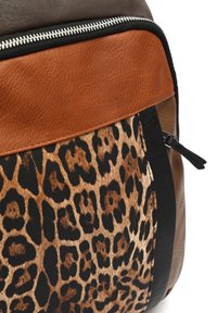Usnjeni nahrbtnik z rjavimi, svetlo rjavimi in črnimi paneli, z značilnim vzorcem leopardje kože na eni strani in srebrnimi zadrgami.