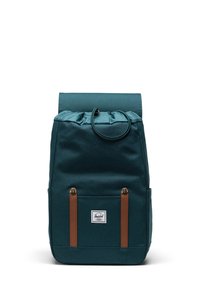 Sac à dos en tissu teal avec une fermeture roll-top, des sangles en cuir marron, une poche avant et un patch logo. Texture lisse avec des bords arrondis.