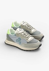 Jasnoszare buty sportowe z zamszowymi i siateczkowymi materiałami, zielonymi akcentami, ciemnymi podeszwami oraz grafiką czaszki z boku. Odbijający światło detal na pięcie.