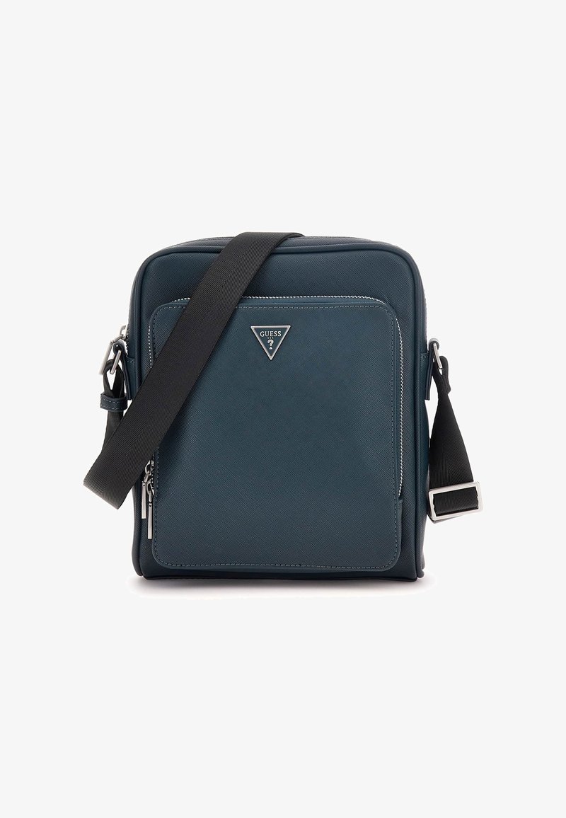Borsa crossbody quadrata di un verde scuro con superficie texture, hardware in argento, tracolla nera regolabile e tasca anteriore con zip.
