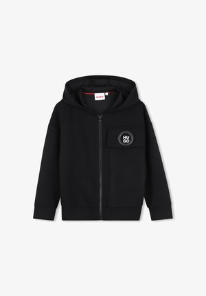 Zwarte hoodie met rits en voorzak op de linkerborst met een ronde logopatch met het woord "HUGO."