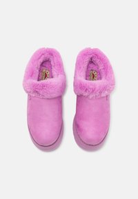 Rosa mockaskor utan snörning med en fluffig rosa syntetpälskrage och vadderad innersula, med en solid sula och minimala detaljer.