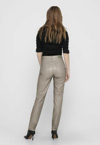 Hoge taille, taupe neplederen broek met een gladde textuur en een taps toelopende pijp, met twee achterzakken en een platte tailleband.