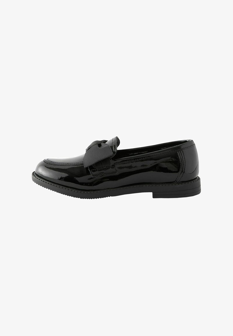 Mocassin en cuir verni noir avec bout arrondi et grand nœud en tissu sur le dessus, semelle plate en caoutchouc, vue latérale.