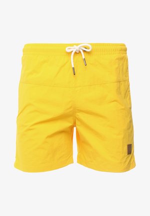 Shorts de bain jaunes en tissu doux et léger, avec une taille élastique et un cordon de serrage blanc. Présente une petite étiquette de marque sur le côté gauche.