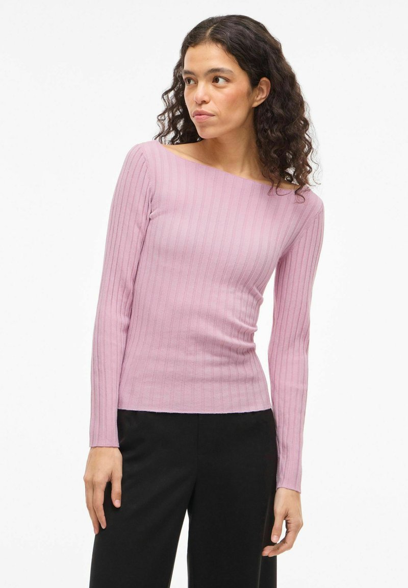 Haut à manches longues côtelé de couleur rose clair, doté d'un col bateau et d'une silhouette ajustée. Allie texture tricotée et design décontracté.