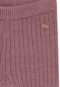 Gerippter, rosa Strickpullover aus Stoff mit umgeschlagenem Kragen und einem kleinen, metallenen Etikett, das an der Seite mit "HUST und CLAIRE" geprägt ist.